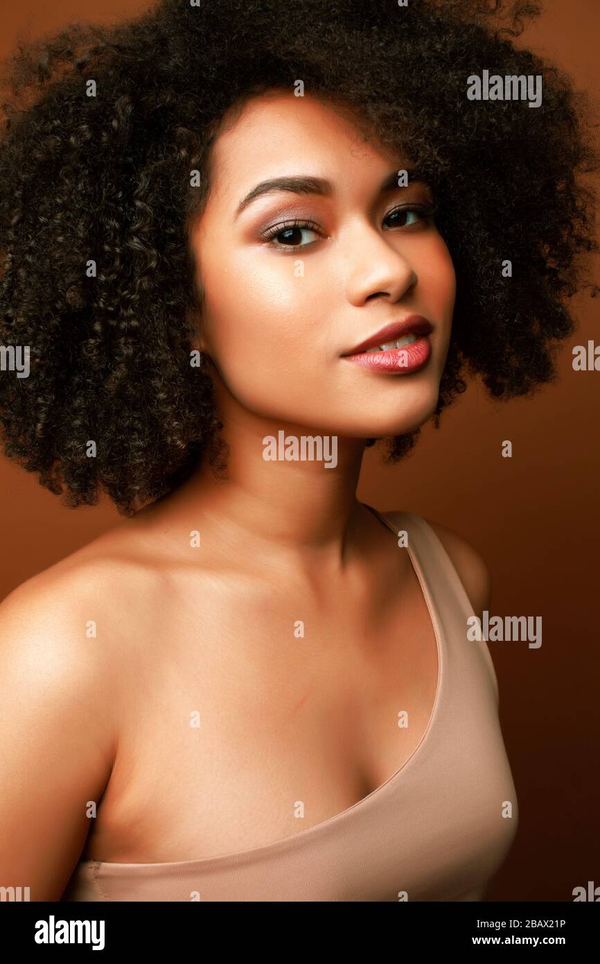 pretty young african american woman with curly hair posing cheerful ...