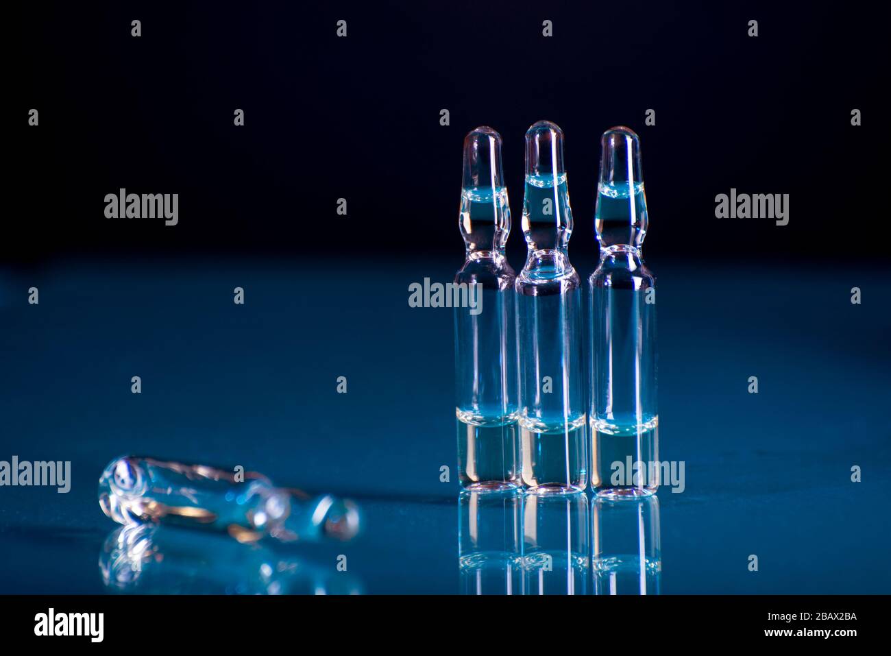 Glass ampoules with liquid for injection against lab flasks in dark