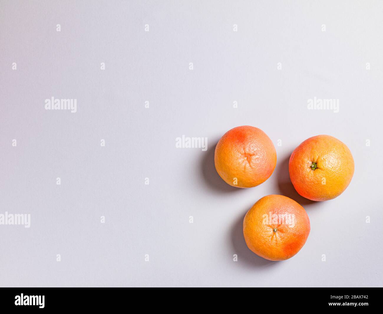Three Fresh Oranges on Grey Background Stock Photo