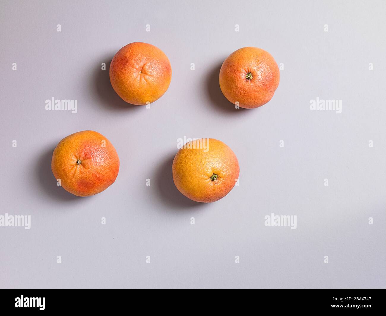Three Fresh Oranges on Grey Background Stock Photo