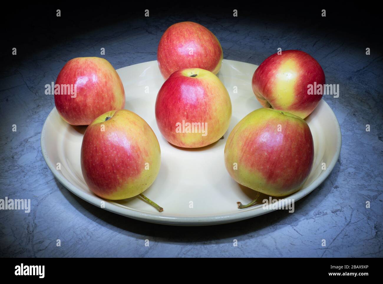 Still life with apples. Ripe apples on a round plate. Red and yellow ...