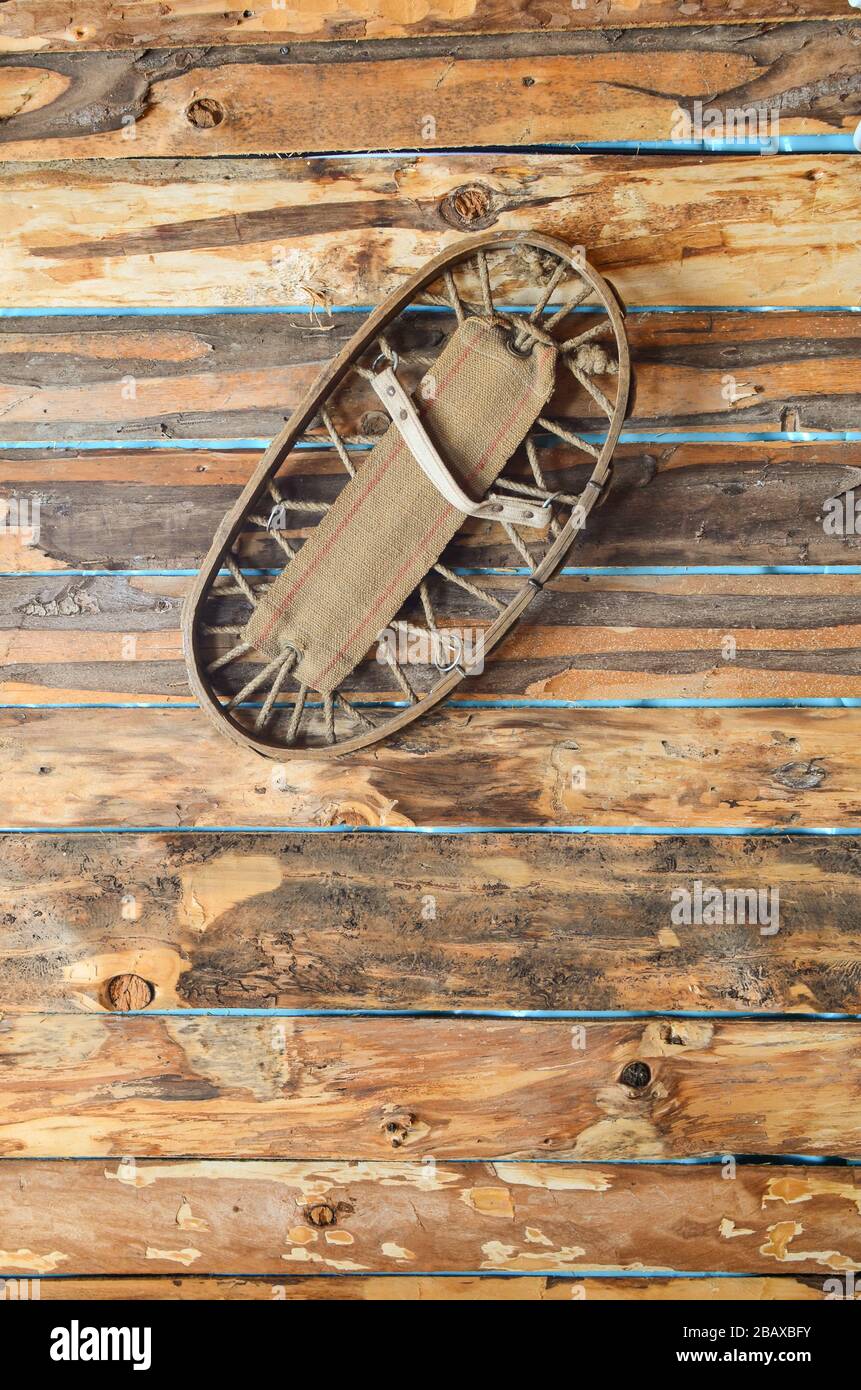 Old, vintage snowshoes as a decoration on the wooden wall of a mountain restaurant Stock Photo
