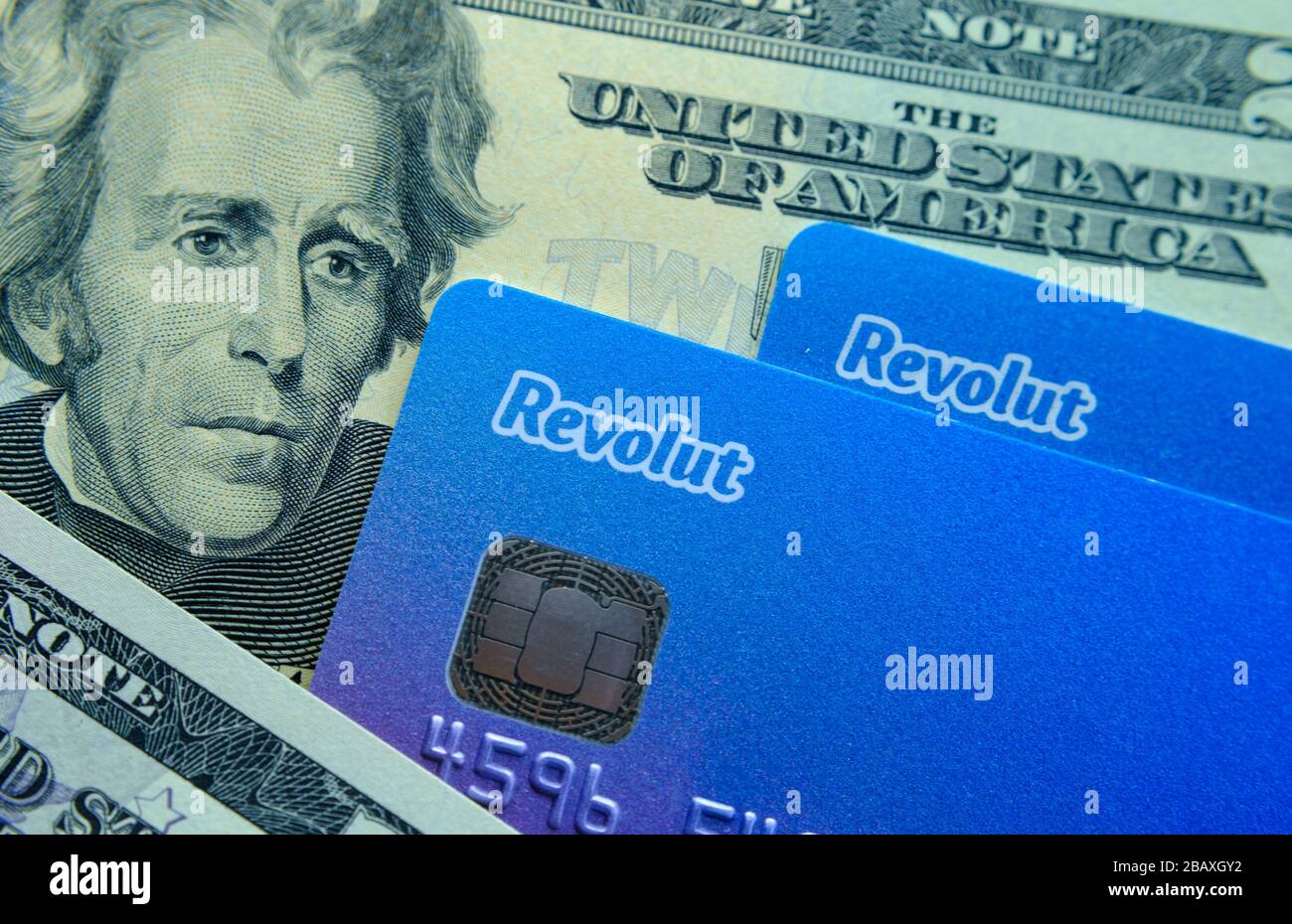 Stone / United Kingdom - March 29 2020: Revolut cards placed on top of dollar notes. Concept photo for revolut bank expansion to American market. Stock Photo