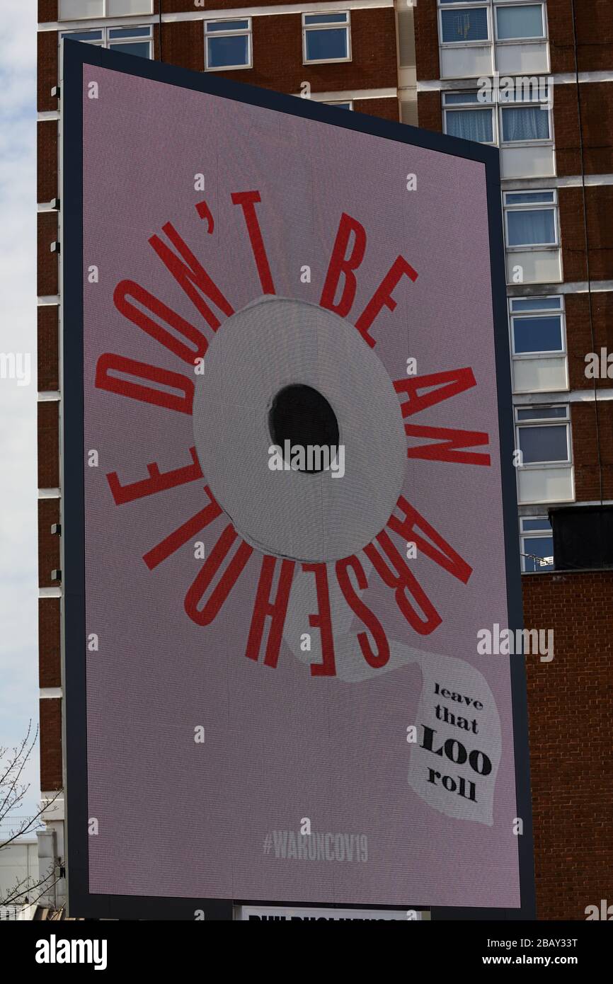 London, U.K. - 28 Mar 2020: An illuminated billboard in west London humorously asks people not to stockpile toilet roll during the coronavirus pandemic. Stock Photo