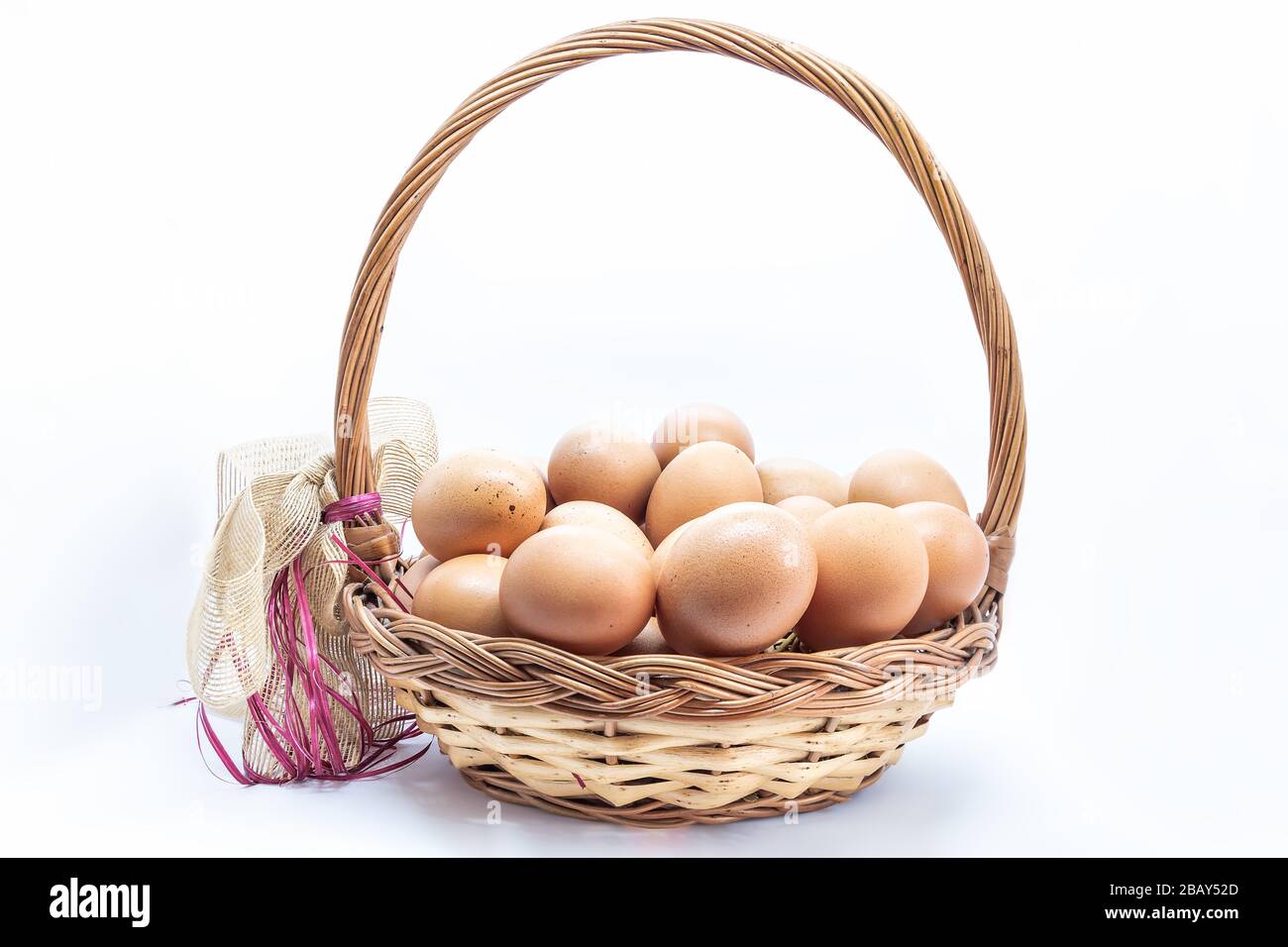 Organic farm eggs in Wicker basket isolated on white background. Chickens eggs from ecologically clean areas Stock Photo