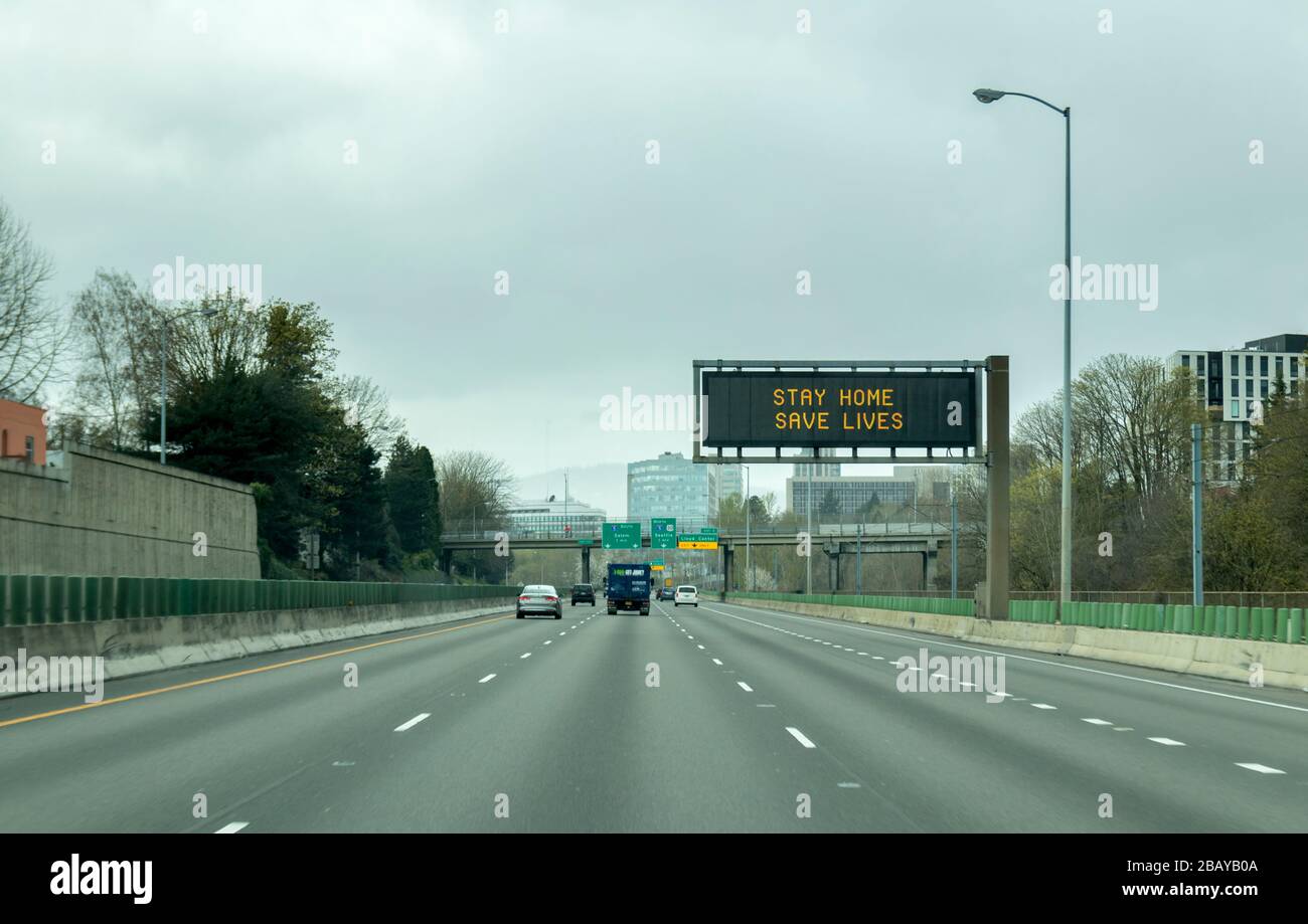 Portland, OR / USA - March 29 2020: Electronic sign on i84 freeway notifying people to stay home and save lives by reducing the risk of being infected Stock Photo