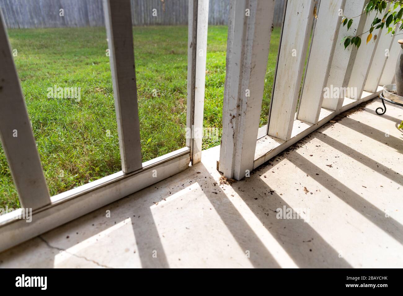 Wooden screen door on back porch with rotten wood Stock Photo