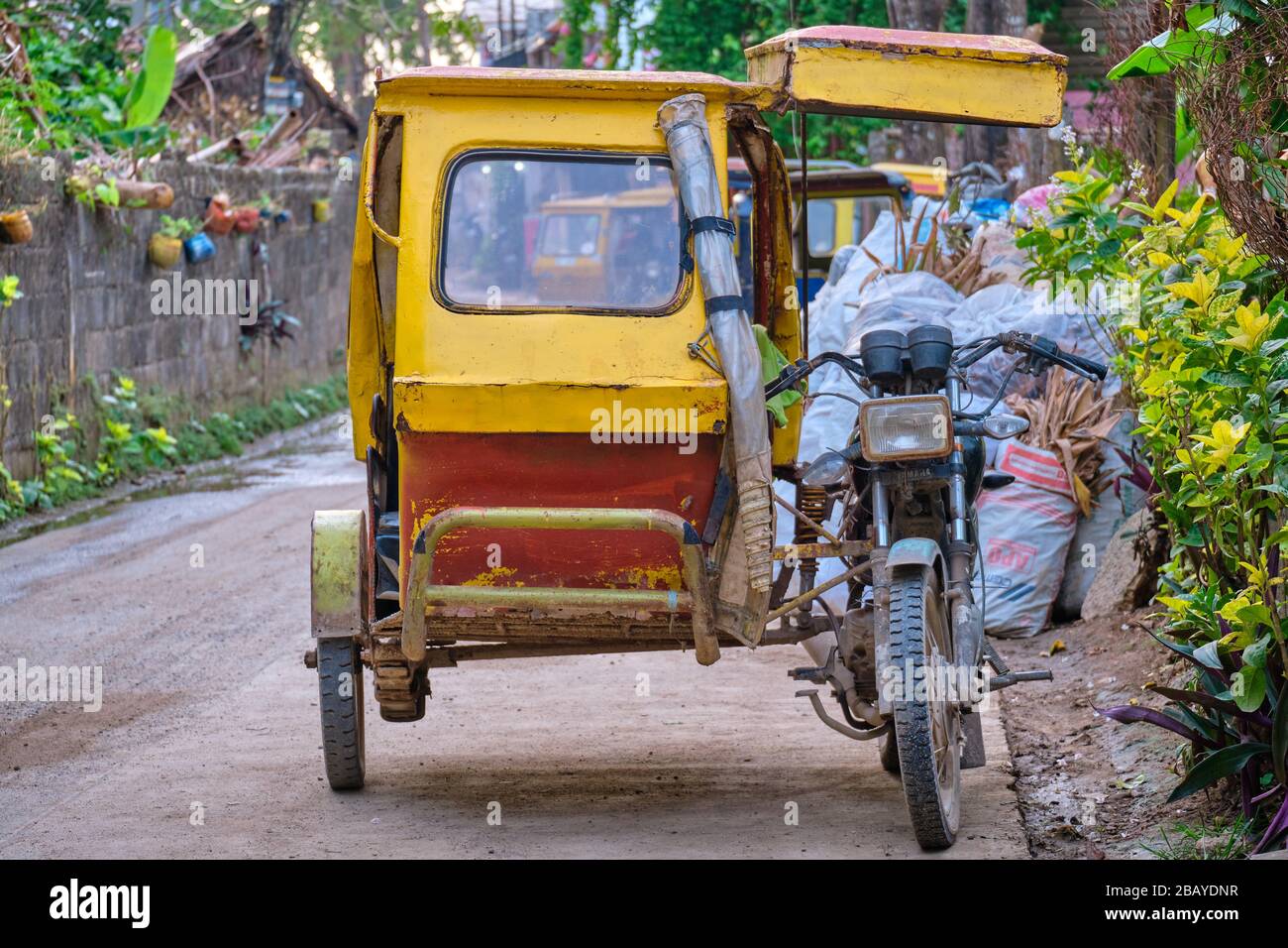 A Filipino yellow tricycle stands on the road Stock Photo - Alamy