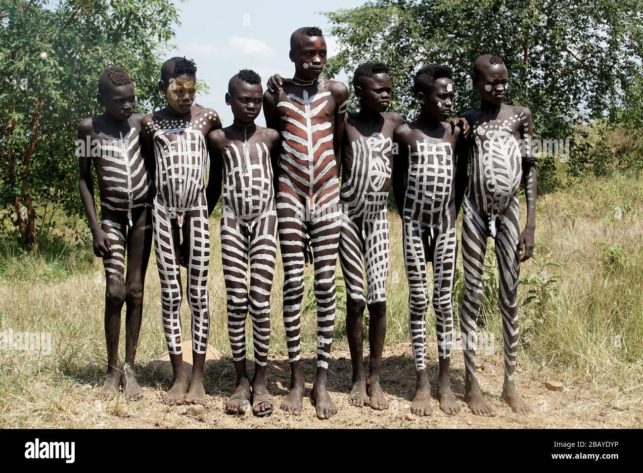 Group of Seven Mursi Tribe Boys with Body Paint all over lined up for a Photograph Stock Photo