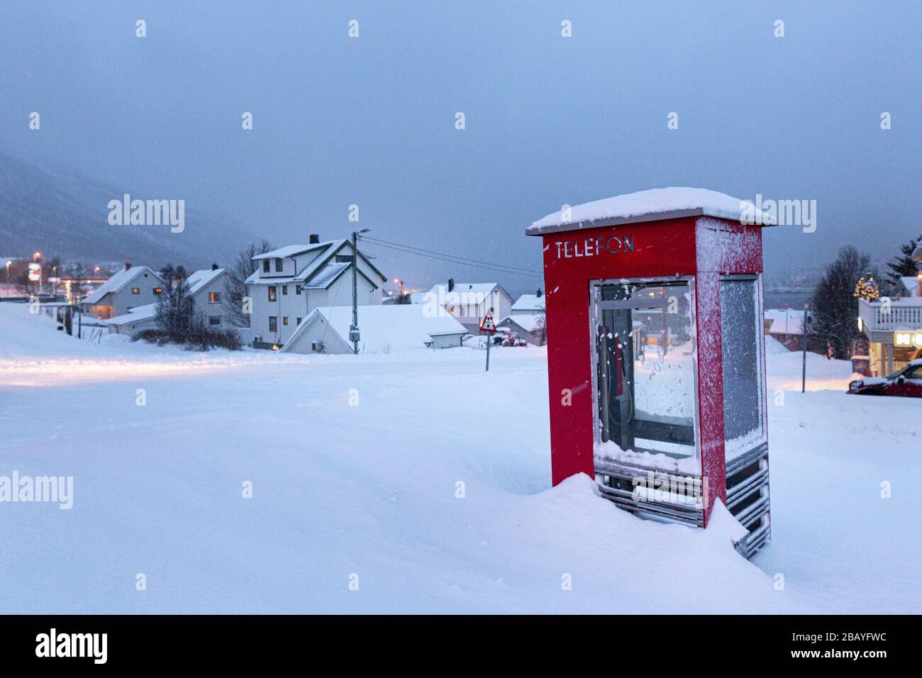 Red phone box in snow at winter in Tromso, Norway in December Stock Photo
