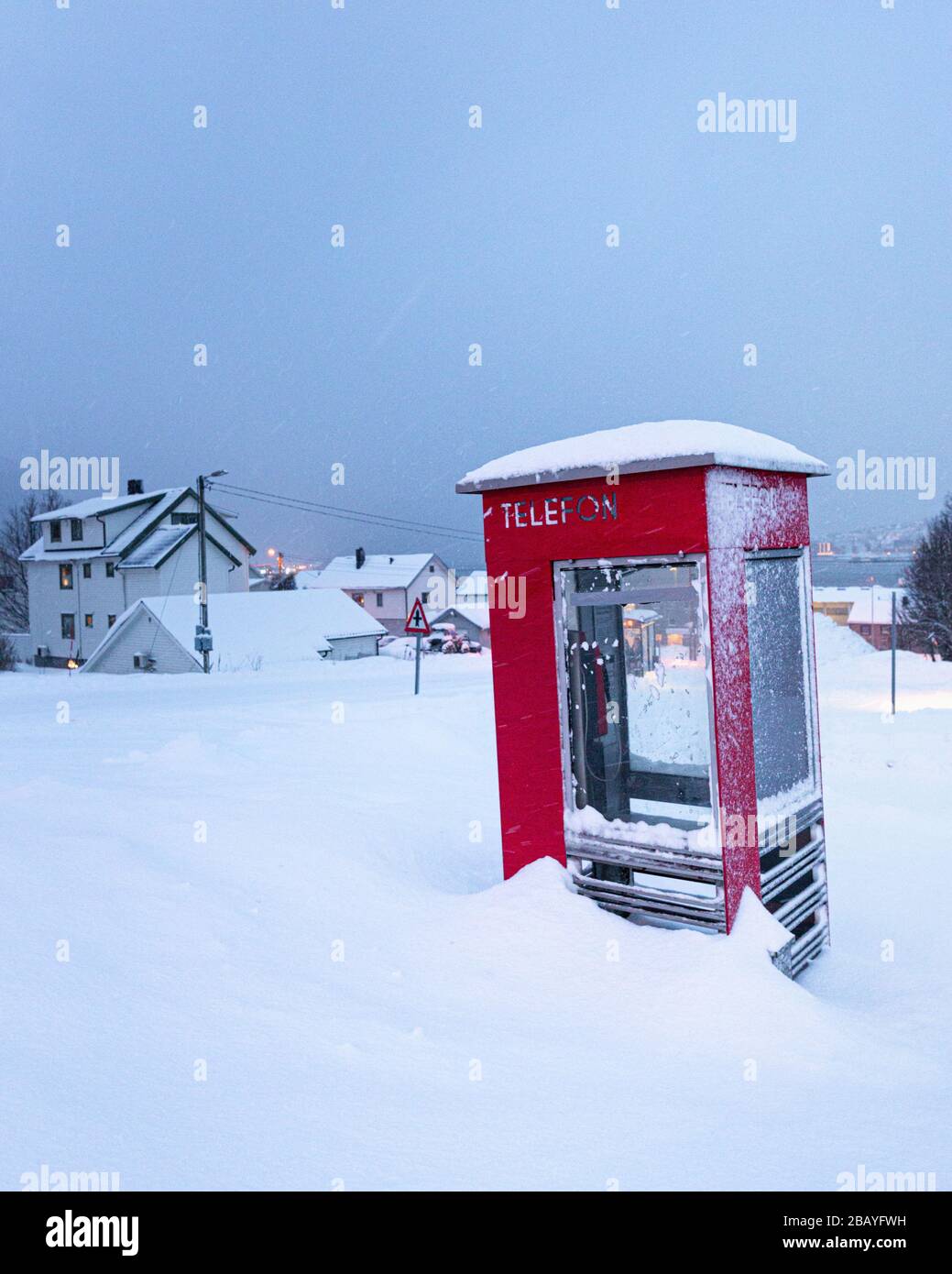 Red phone box in snow at winter in Tromso, Norway in December Stock Photo