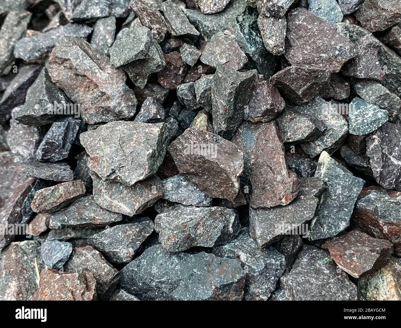 Rough stones, crushed stone, granite gravel close-up. The rough texture of the stone. Building material background. Texture. Stock Photo