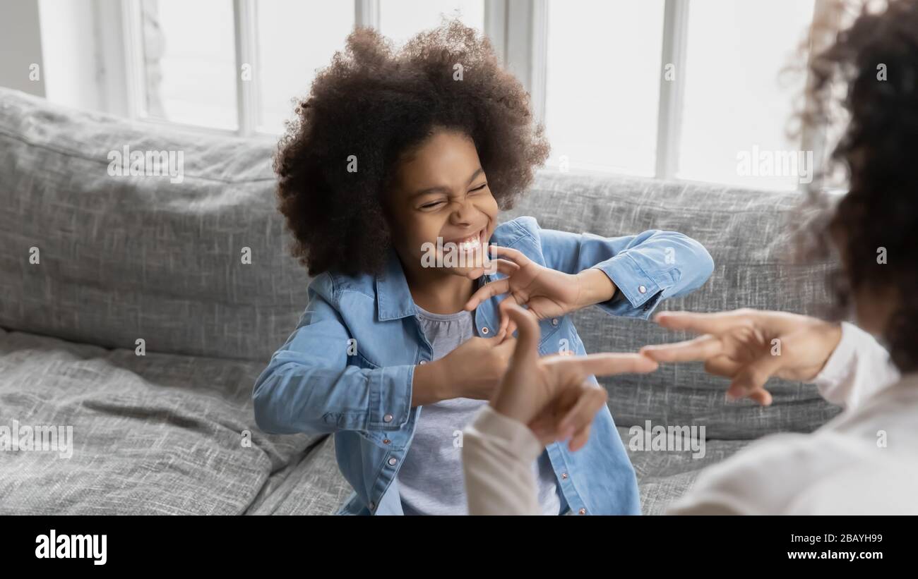 African little girl using sign language communicates with mom Stock Photo