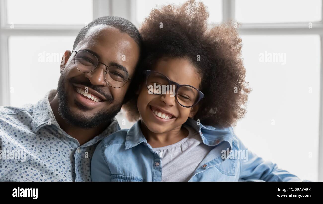 African father little daughter in glasses with toothy smile portrait Stock Photo