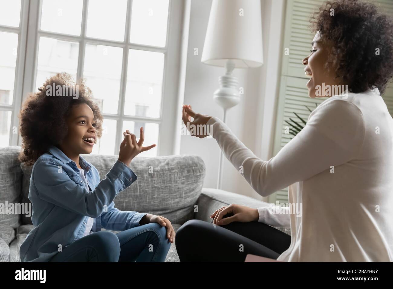 African little daughter using sign language communicates with mother Stock Photo