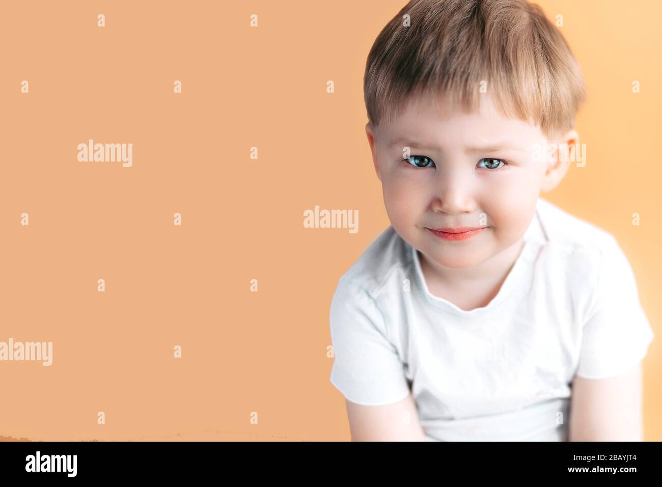 Sad, thinking. Closeup portrait headshot depressed, alone, tired child on orange background. Negative human emotion face expression feeling life Stock Photo