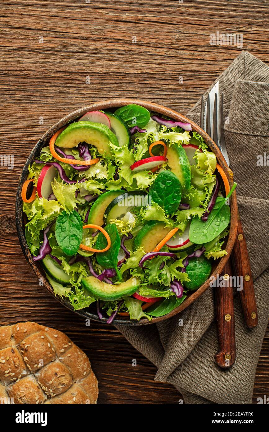 Green lettuce salad meal with fresh vegetables on wooden table background Stock Photo