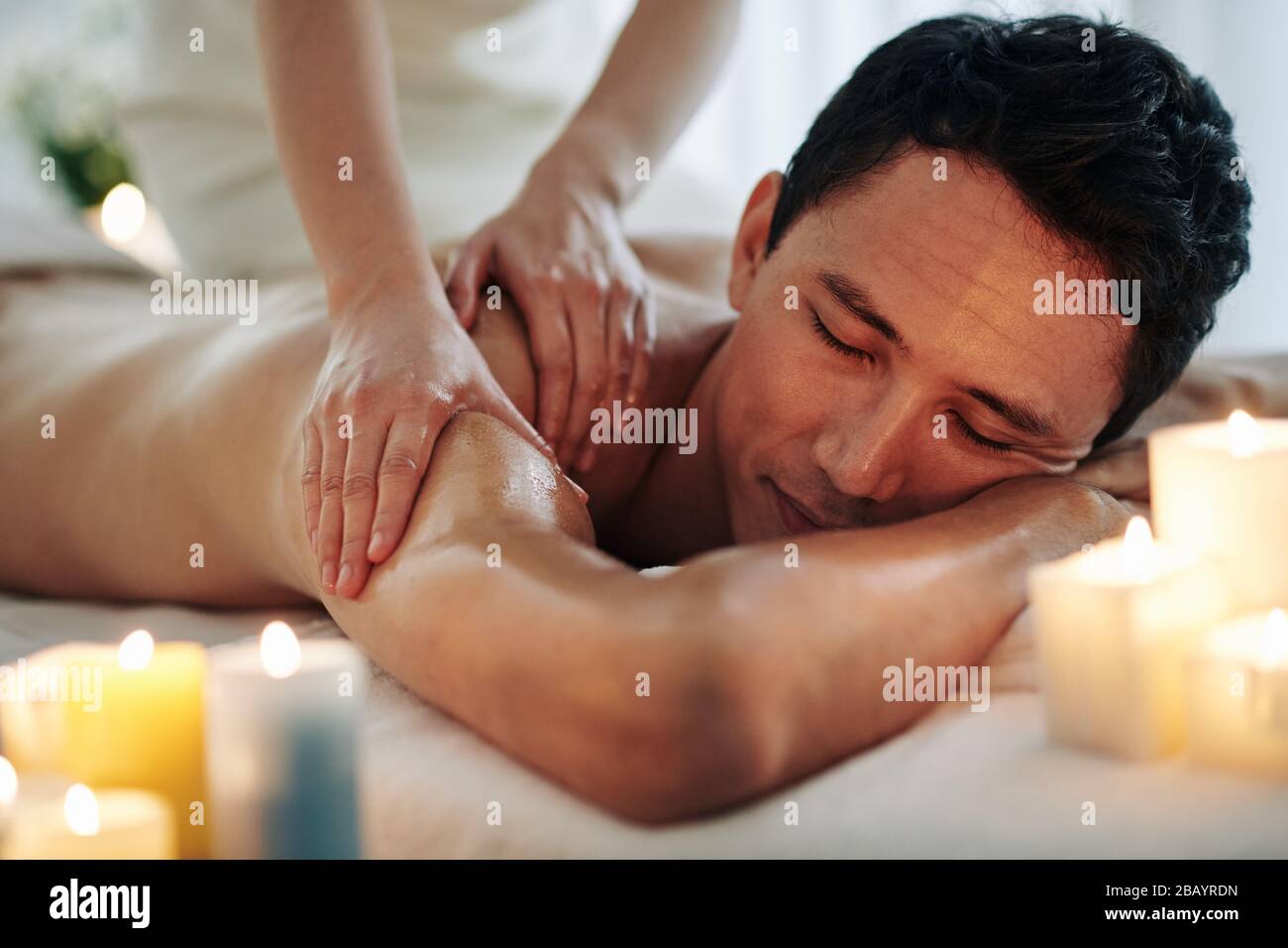 Handsome middle-aged man enjoying relaxing spa massage with oils Stock Photo