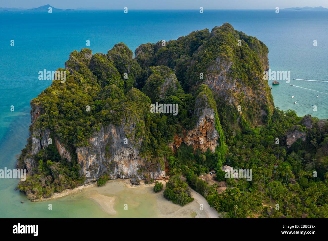 Aerial view of towering limestone cliffs and lush green jungle next to a tropical beach (Railay Beach, Thailand) Stock Photo