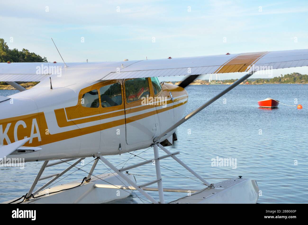 A yellow and white Cessna 172 Skyhawk seaplane taxiing out for takeoff among islands in the Kragerø archipelago on south coast of Norway. Stock Photo