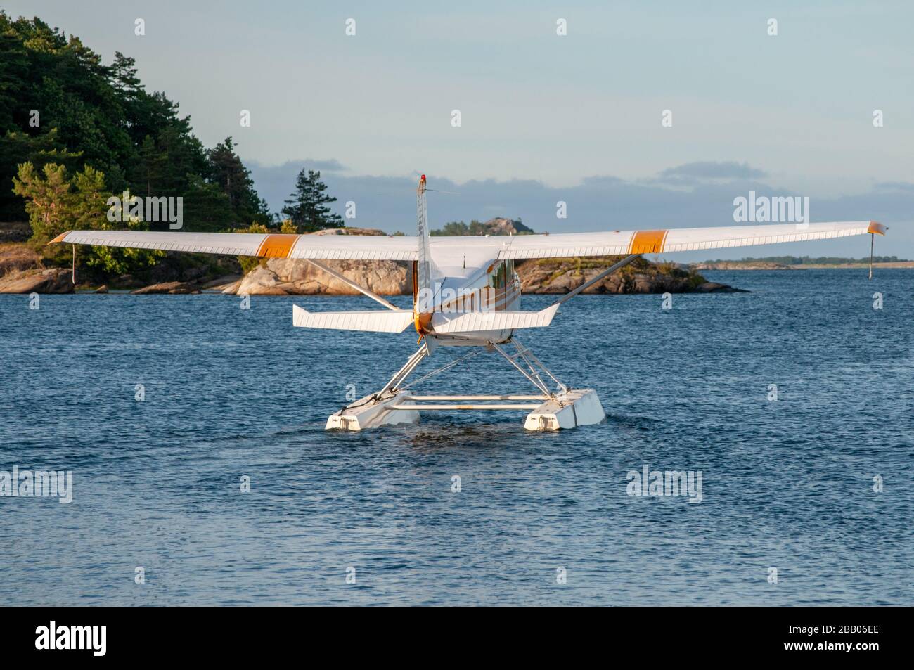 A yellow and white Cessna 172 Skyhawk seaplane taxiing out for takeoff among islands in the Kragerø archipelago on south coast of Norway. Stock Photo