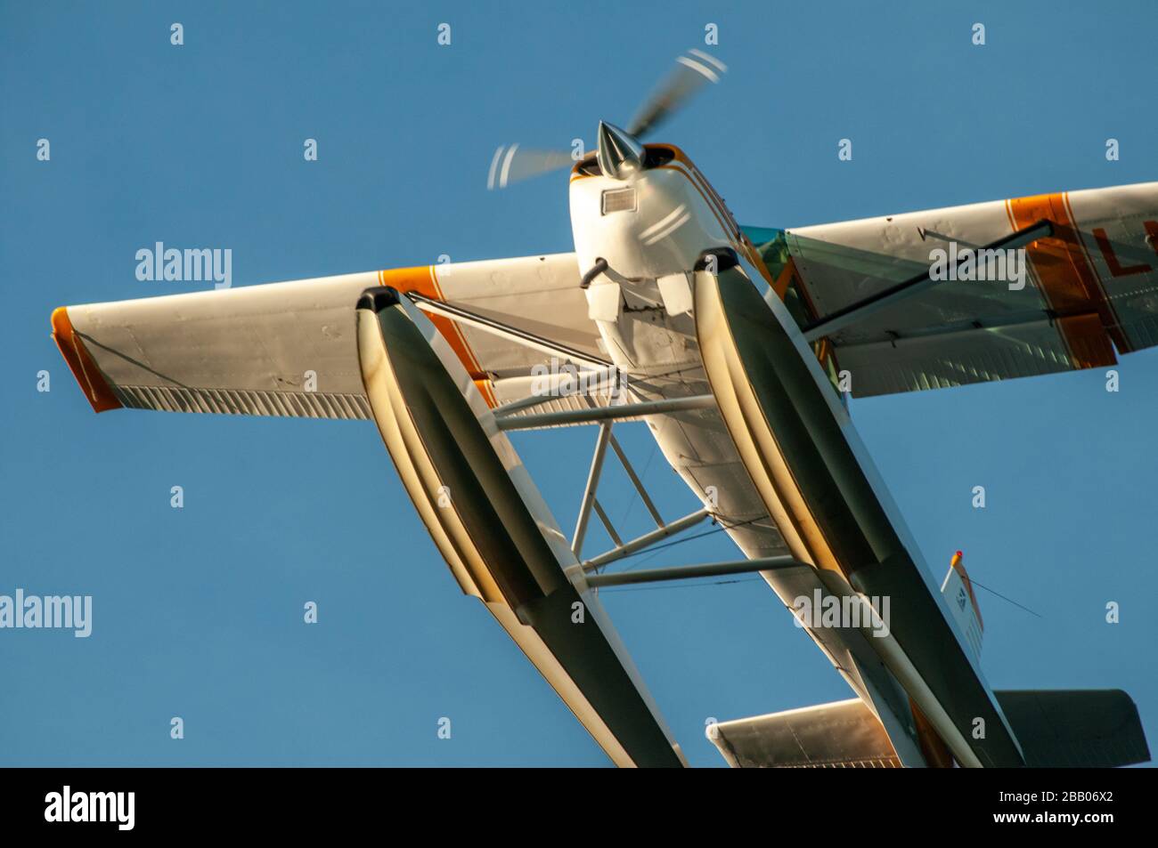 Closeup of a yellow and white Cessna 172 Skyhawk seaplane taking off among islands in the Kragerø archipelago on south coast of Norway. Stock Photo