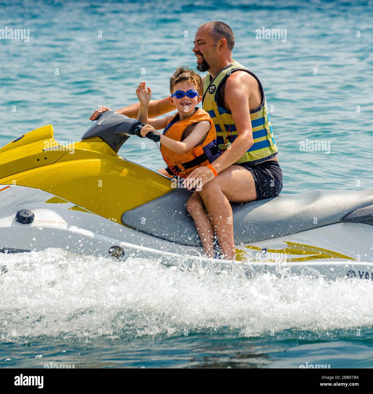 Caucasian father and 6 year old son wearing life jackets sharing family fun  on a power jet ski on the Black sea coast, medium long shot,varna bulgaria  Stock Photo - Alamy
