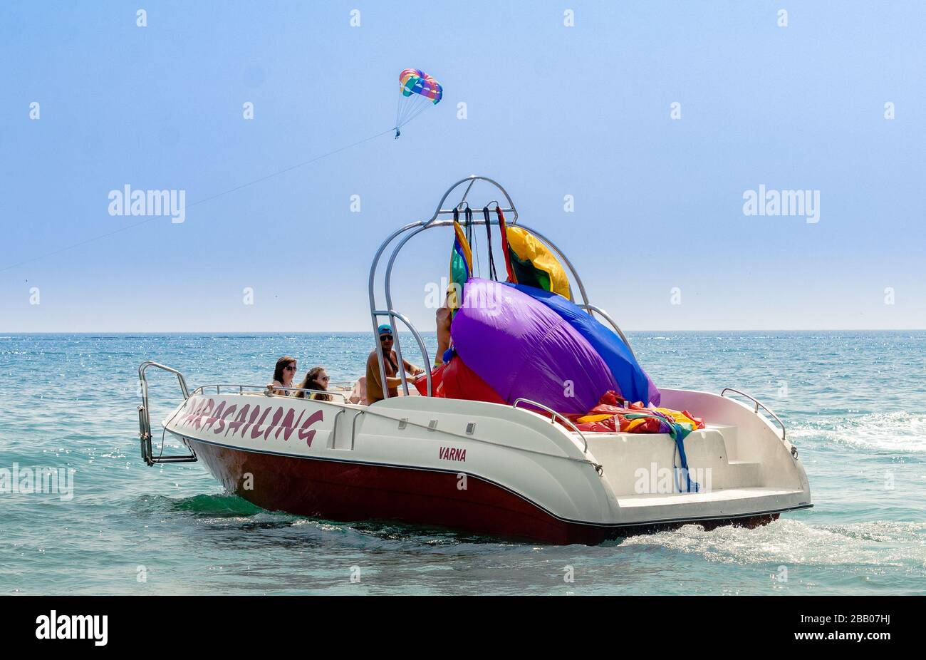Holiday makers prepare for parasailing ride from power boat with