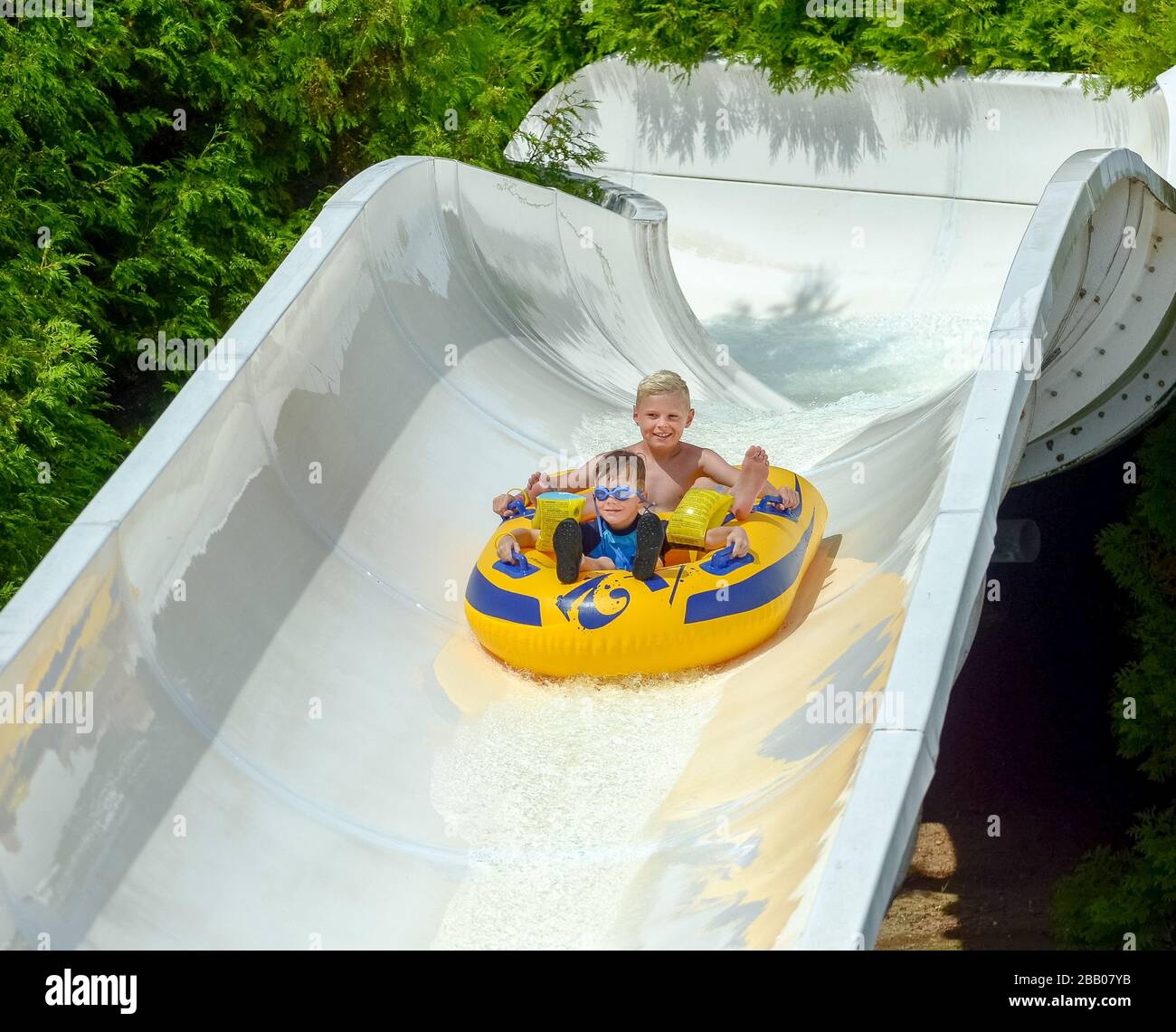 Two young caucasian boys on holiday having fun on thrilling water chute amusement ride at aqua family fun park Varna Bulgaria Stock Photo
