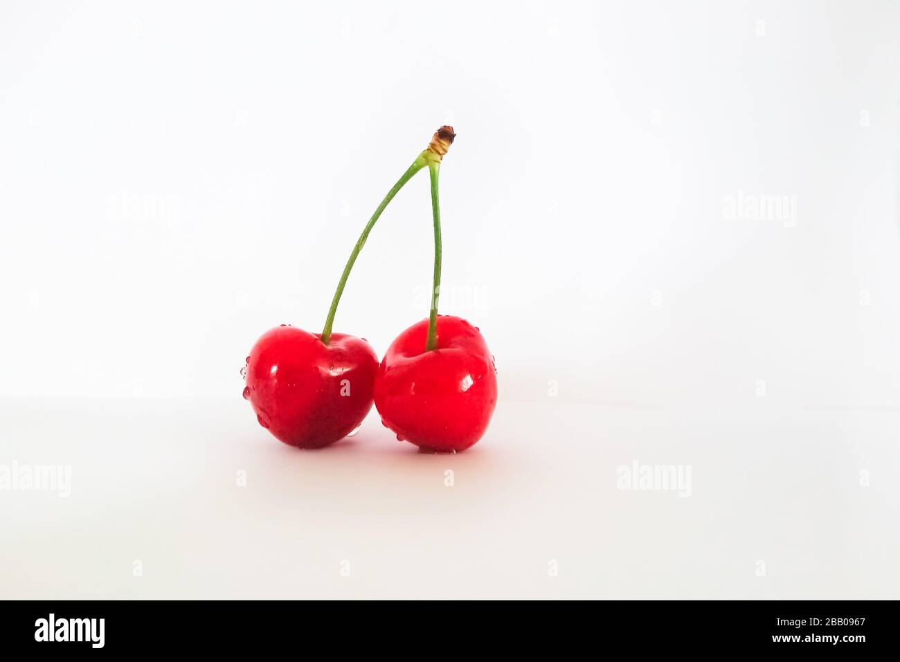 Two red cherries isolated on white background Stock Photo