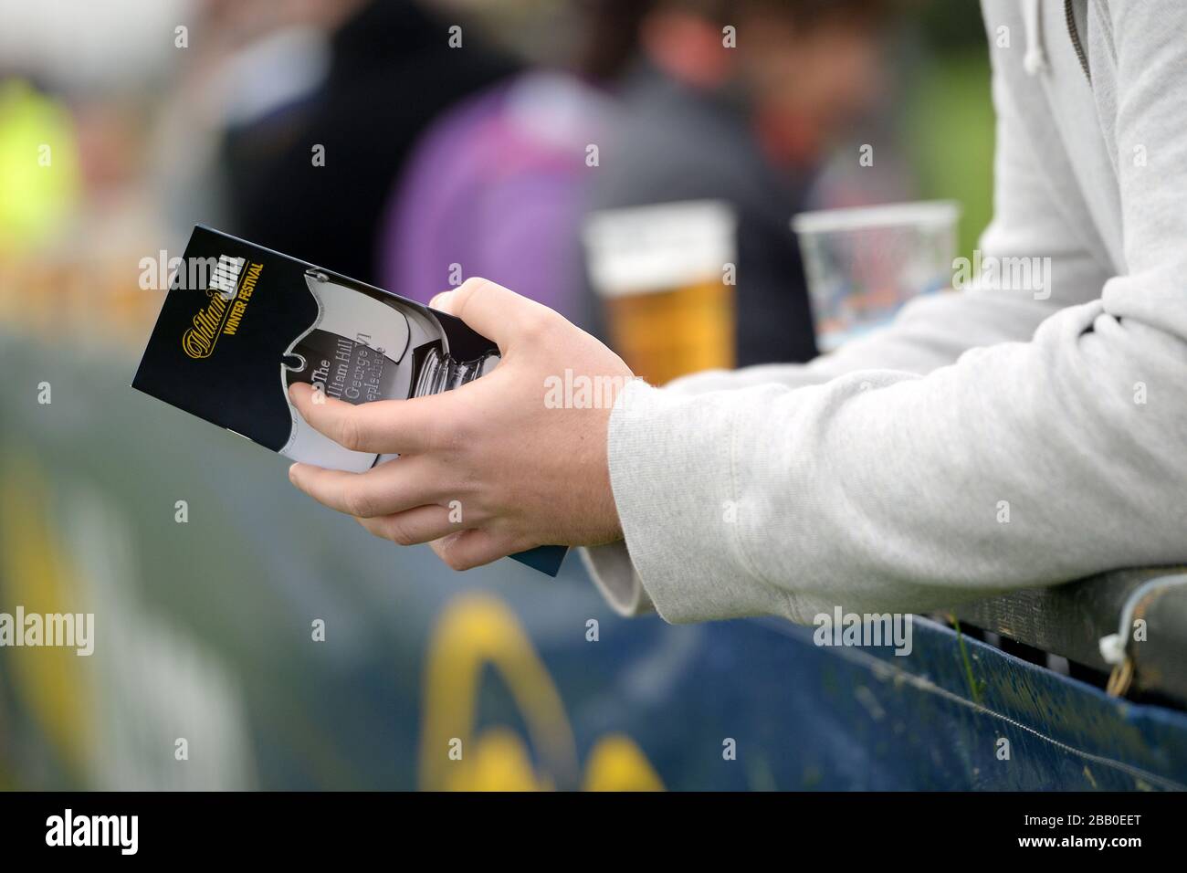 A member of the crowd holding the William Hill Winter Festival race programme Stock Photo