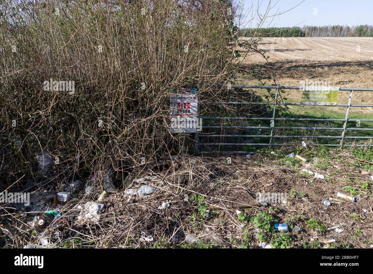 Fly tipping in an English country lane, in front of a Site Under Surveillance notice, Northampton, UK Stock Photo