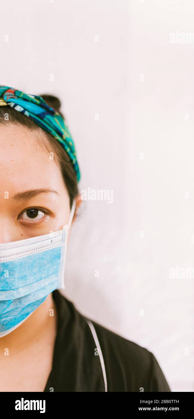 Coronavirus theme. Asian woman  wearing a mask to protect herself from getting infected on a white background. Stock Photo