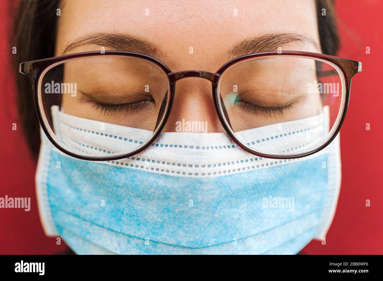 coronavirus theme. Asian woman with glasses wearing a mask to protect herself from getting infected Stock Photo