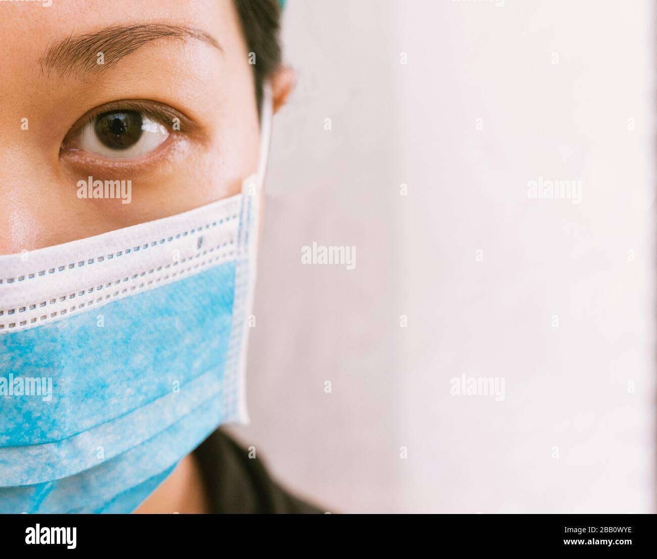 Coronavirus theme. Asian woman  wearing a mask to protect herself from getting infected on a white background. Stock Photo