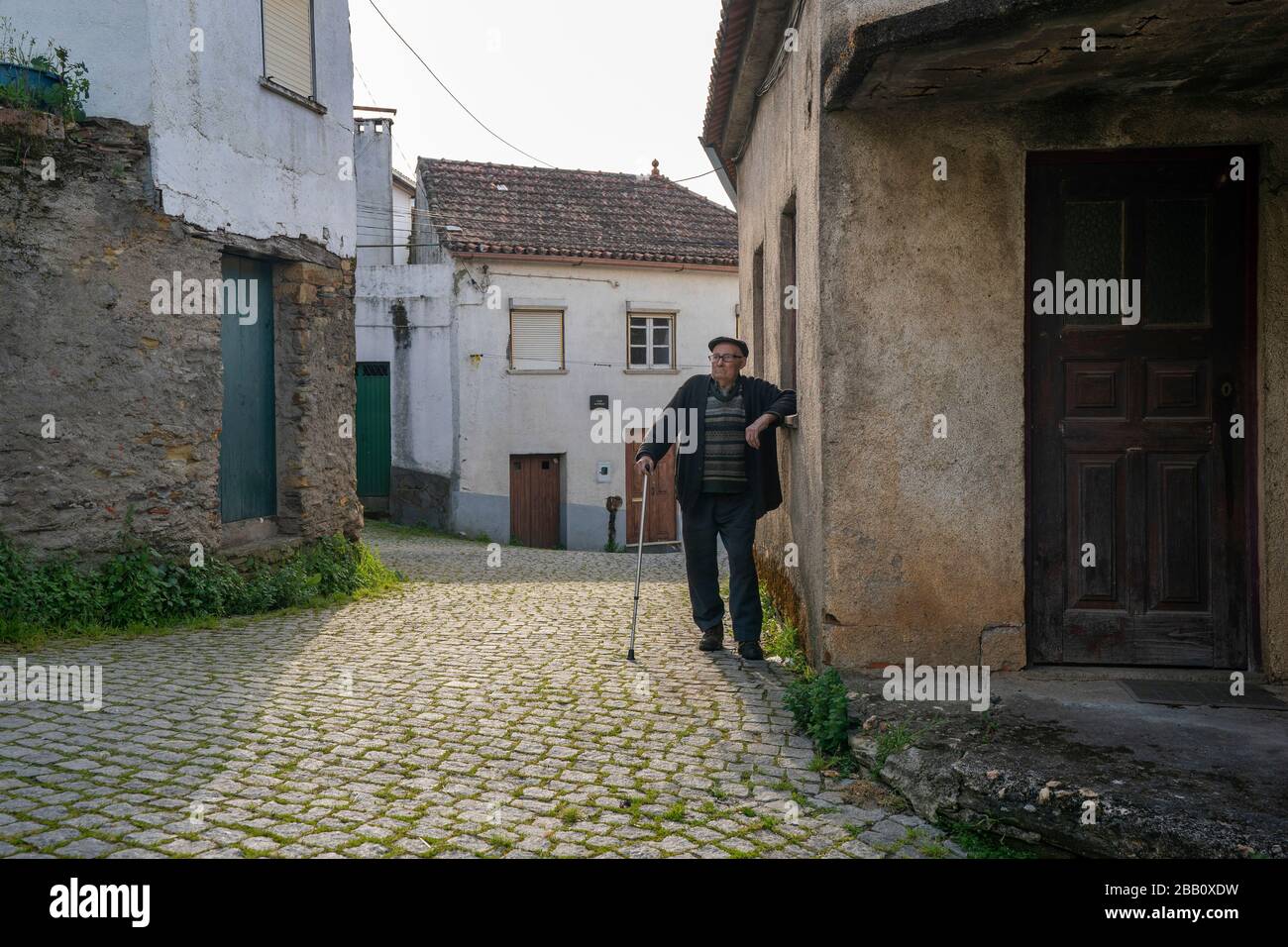 Portrait of an elderly man with cane alone in a village Stock Photo