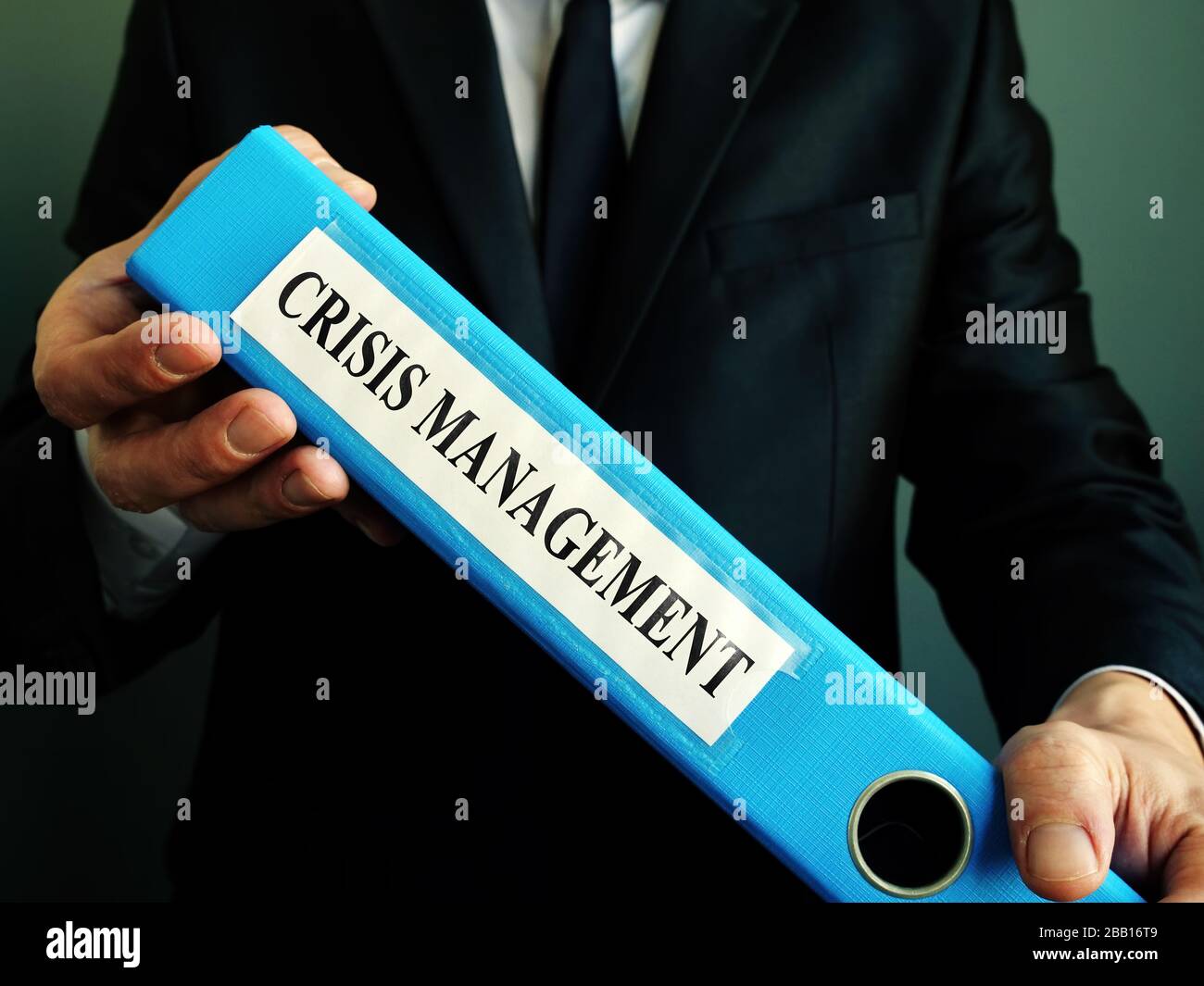 Manager holds crisis management plan in the blue folder. Stock Photo