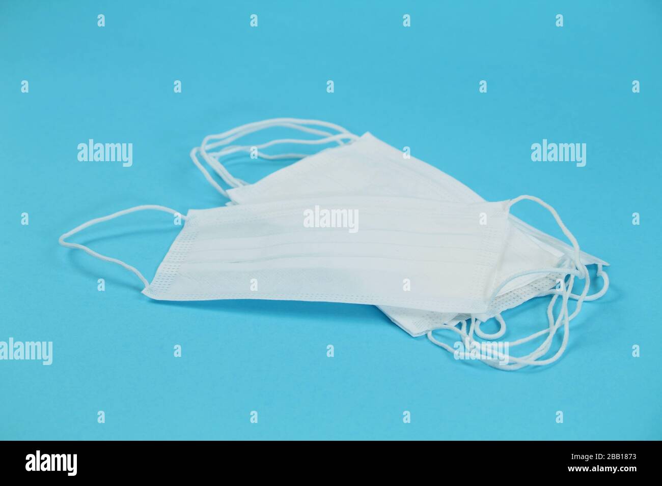 Disposable Medical masks on blue background. Covid-19 and healthcare concept Stock Photo