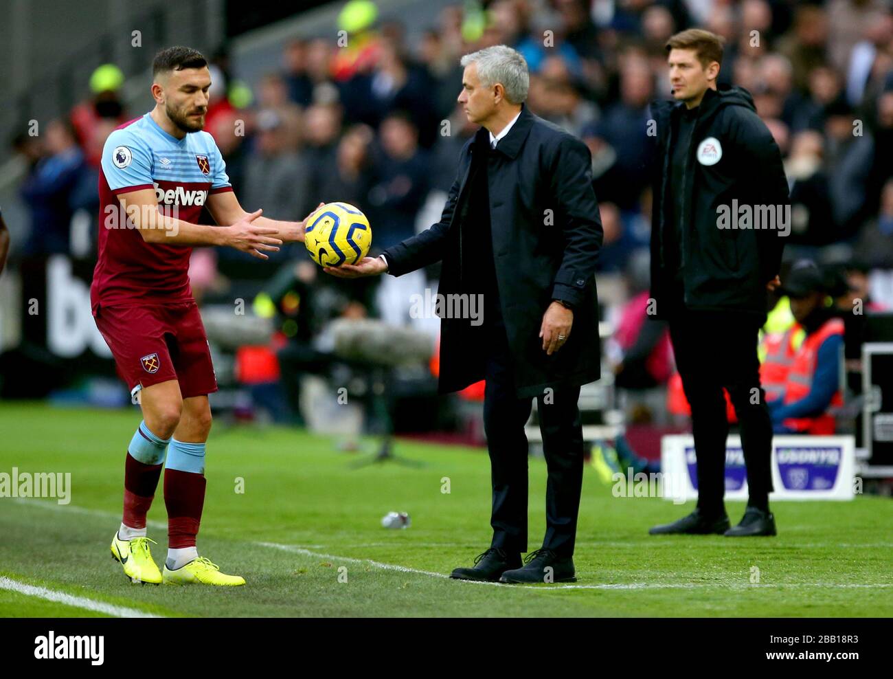 Tottenham Hotspur manager Jose Mourinho (centre) gives the ball to West Ham United's Robert Snodgrass Stock Photo