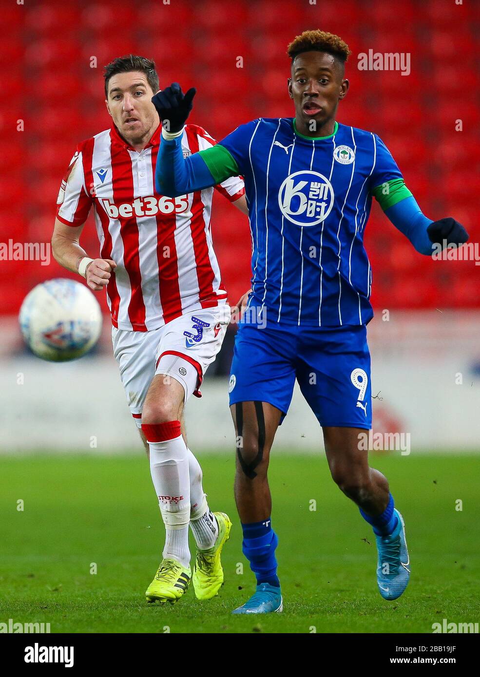 Stoke City's Stephen Ward and Wigan Athletic's Jamal Lowe during the Sky Bet Championship at the bet365 Stadium Stock Photo