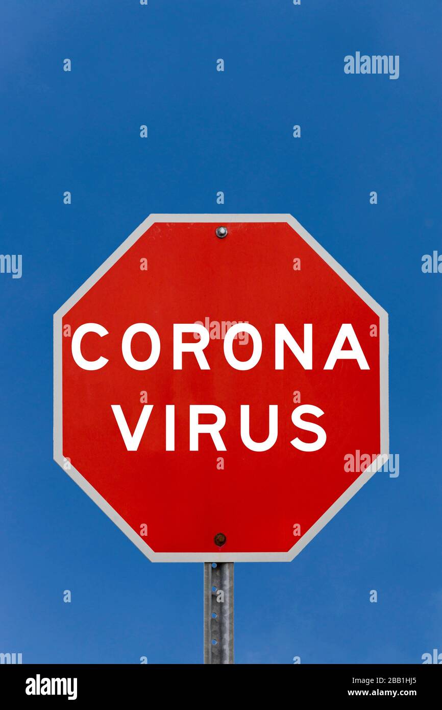 Corona virus warning sign with clear blue sky background Stock Photo