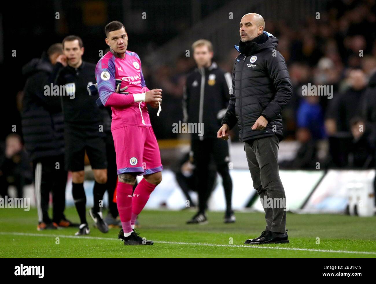 Manchester City goalkeeper Ederson (left) speaks to manager Pep Guardiola after receiving a red card from Referee Martin Atkinson Stock Photo