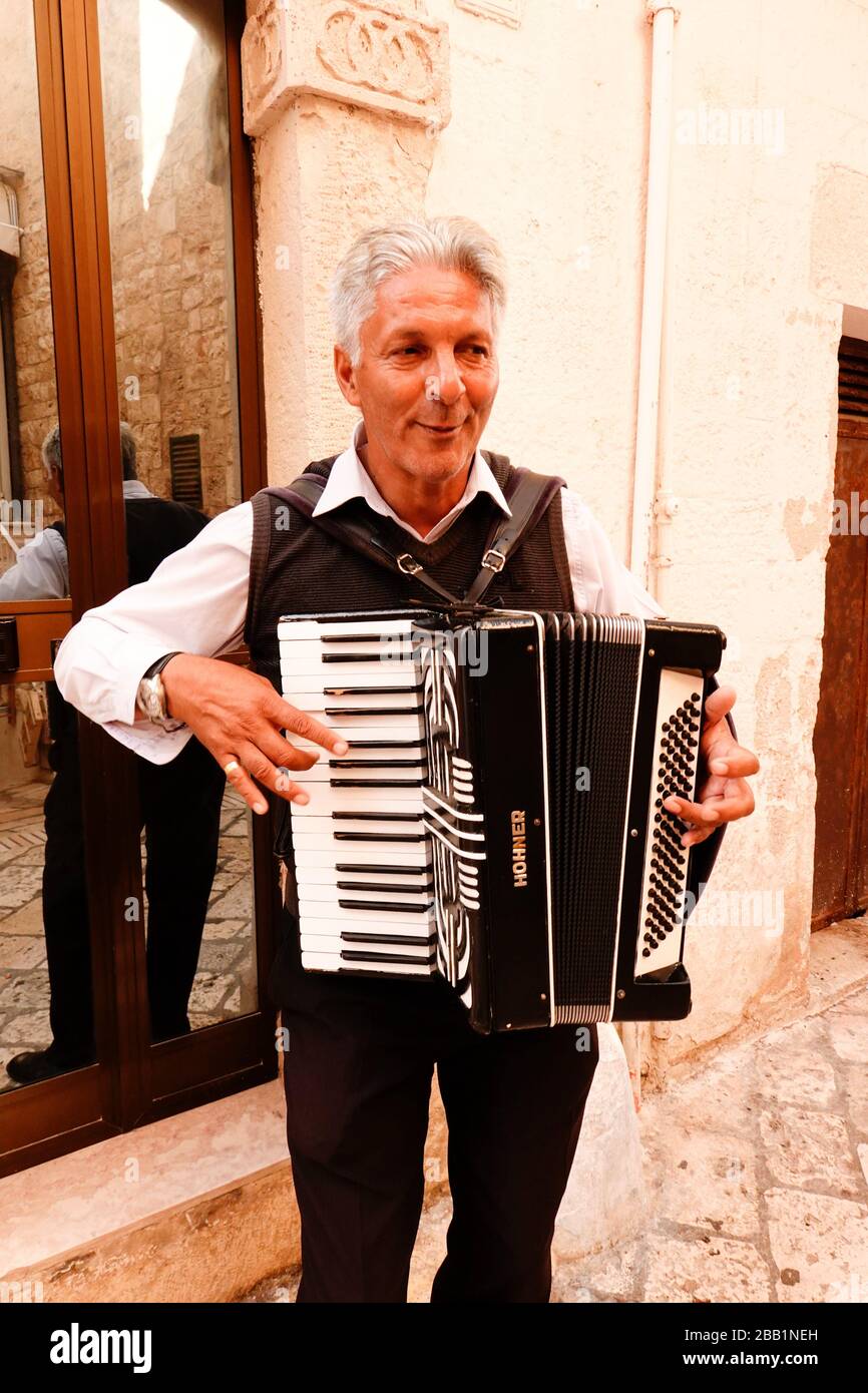 An accordionist plays in the street in Polignano a Mare, Puglia, Italy. Stock Photo