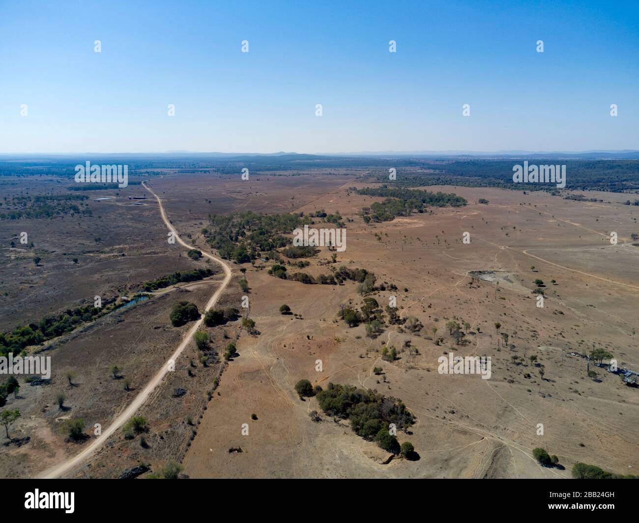 Aerial of a unsealed road leading into pastoral properties in the Central Highlands of Queensland Australia Stock Photo