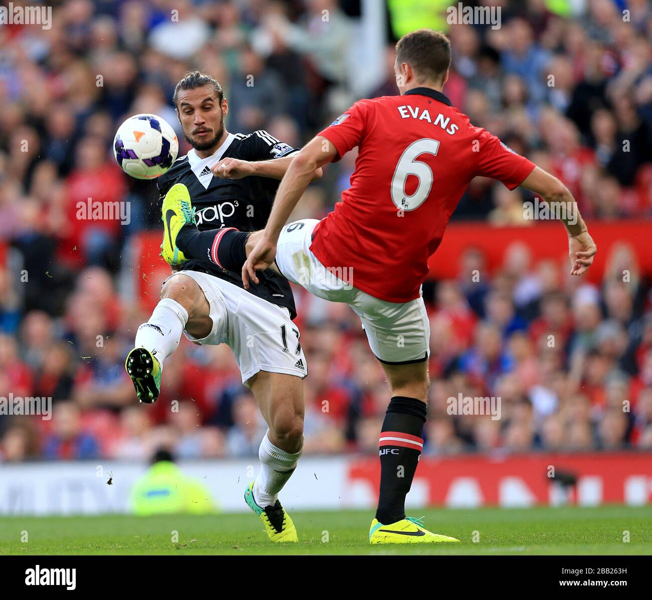 Manchester United's Jonny Evans (right) and Southampton's Pablo Osvaldo battle for the ball Stock Photo