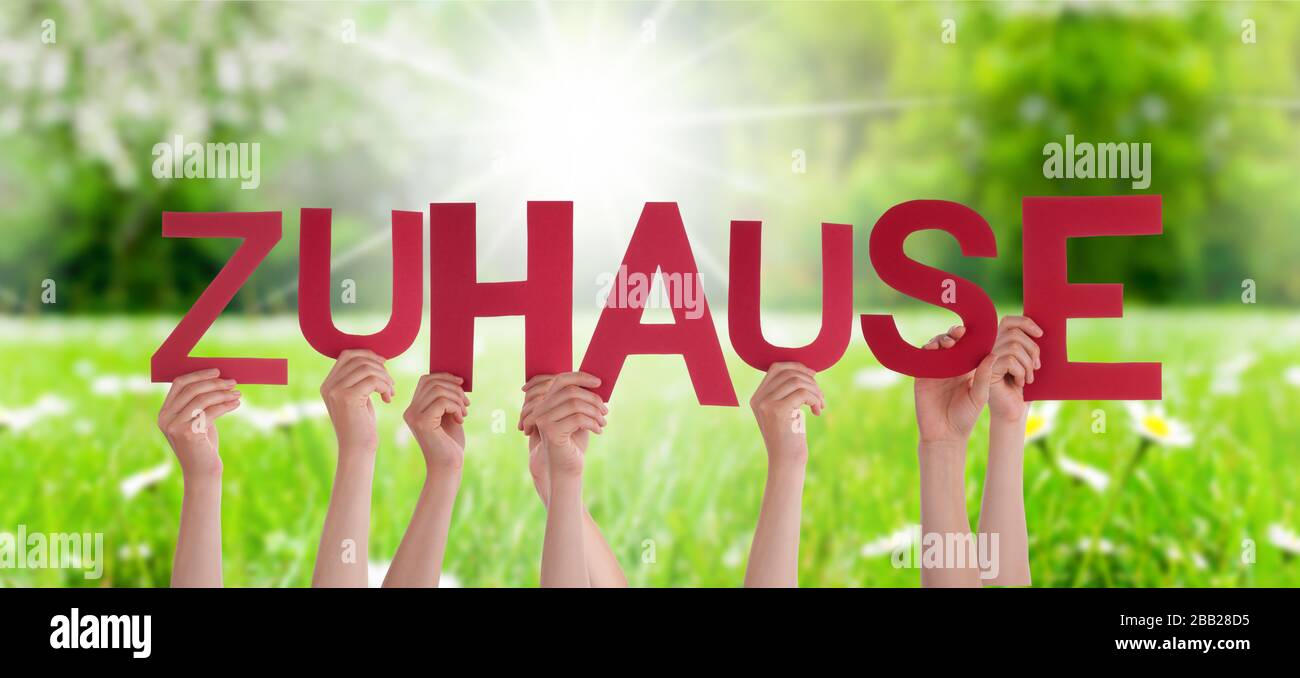 People Hands Holding Word Zuhause Means Home, Grass Meadow Stock Photo