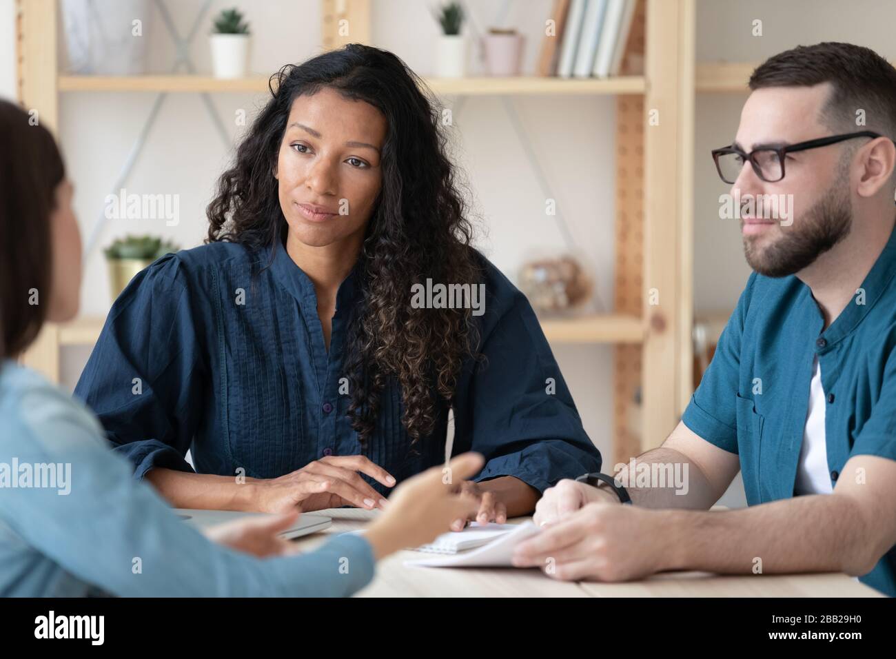 Pensive businesspeople consider cooperation with partner at meeting Stock Photo
