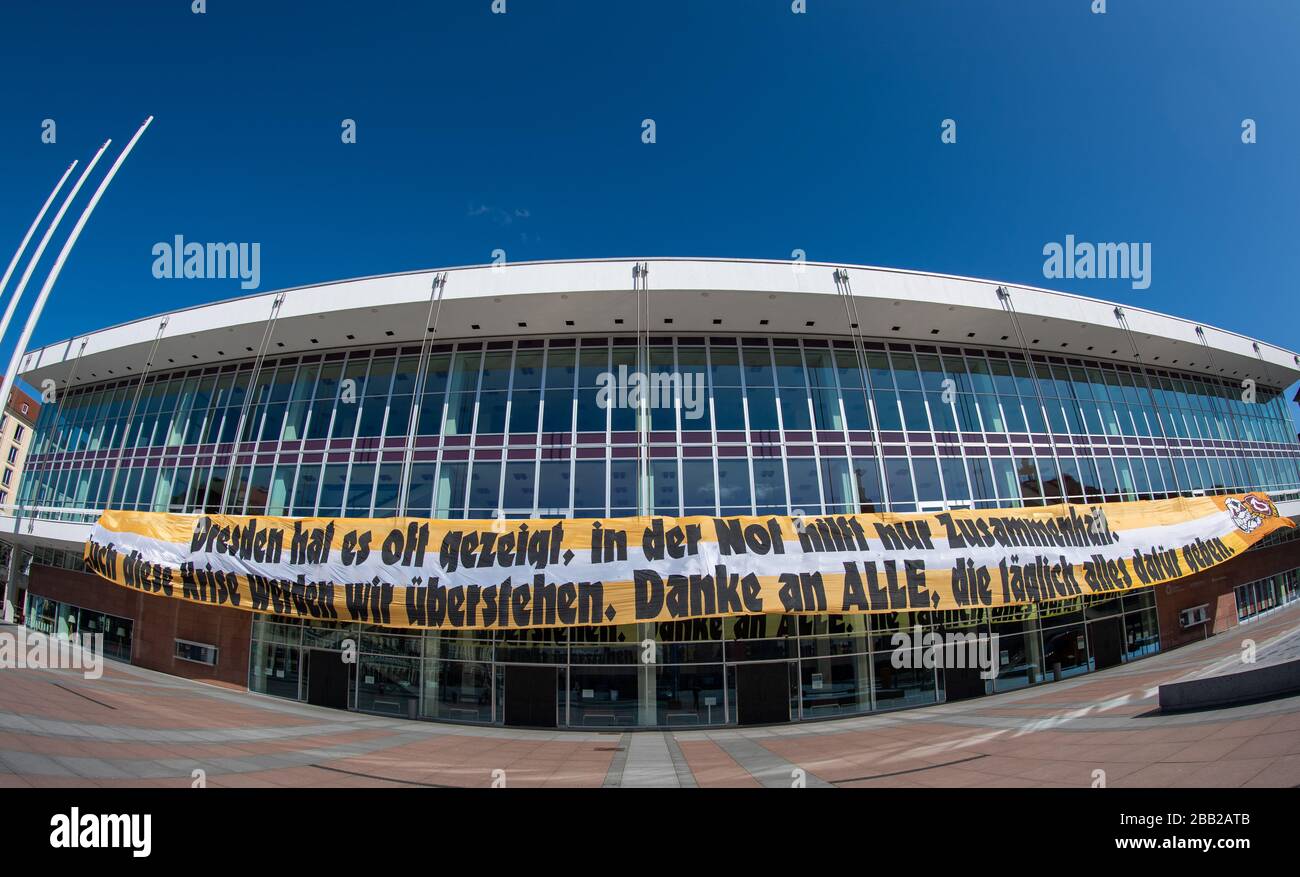 30 March 2020, Saxony, Dresden: The Ultras of the second division football team SG Dynamo Dresden have a banner at the Kulturpalast with the inscription 'Dresden has often shown that in times of need only solidarity helps. We will also survive this crisis. Thanks to all who give their all every day'. The banner, which was made on the initiative of the fans of Dynamo Dresden ('Ultras') and initially hung on the terrace bank, was thus given a new place. The Lord Mayor of the state capital of Dresden, Dirk Hilbert, had campaigned to hang it on the Kulturpalast as a central house of encounter and Stock Photo