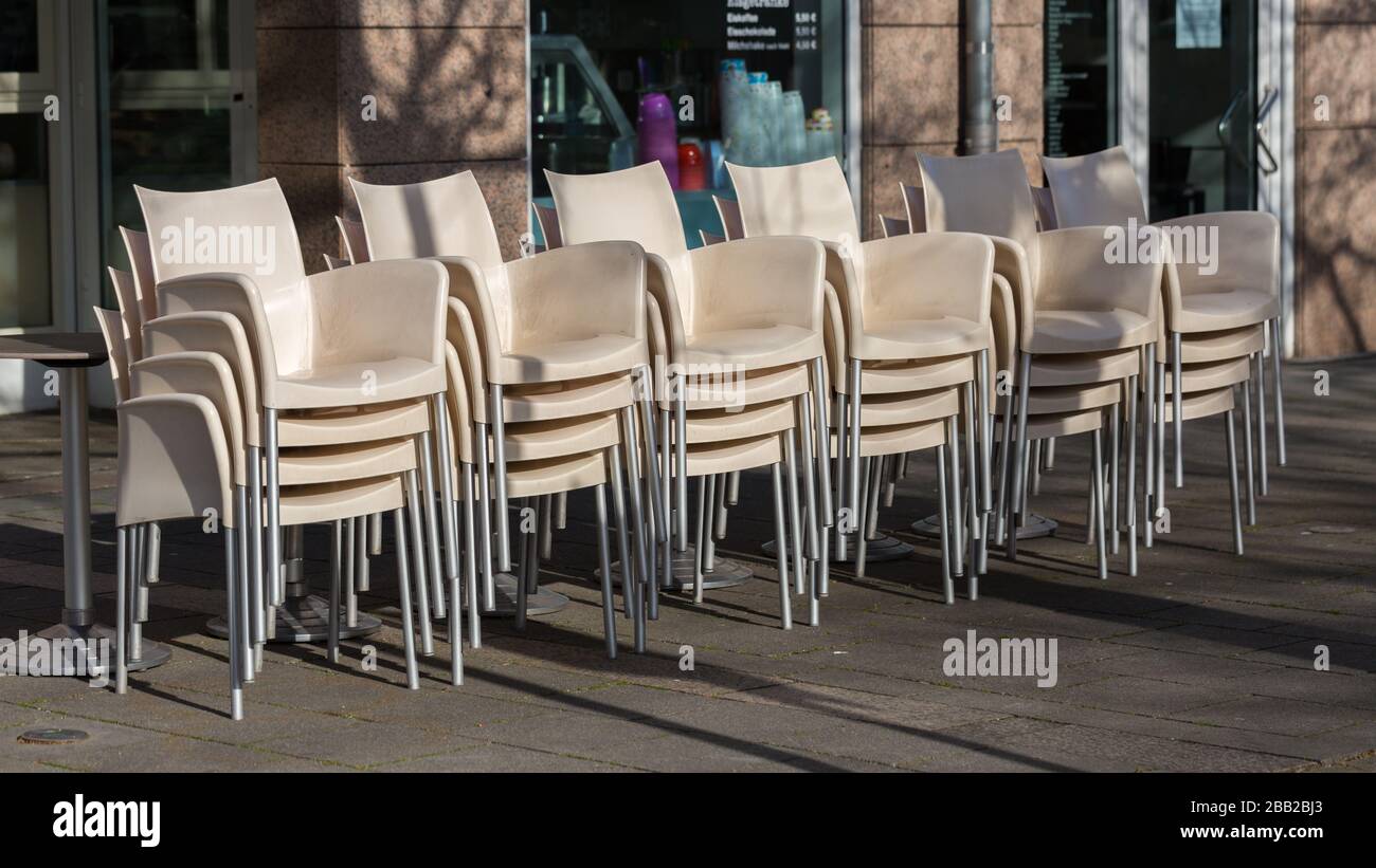 Stacked chairs in front of a restaurant in Starnberg. Due to the restrictions related to the Coronavirus (Covid-19) many restaurants are closed. Stock Photo