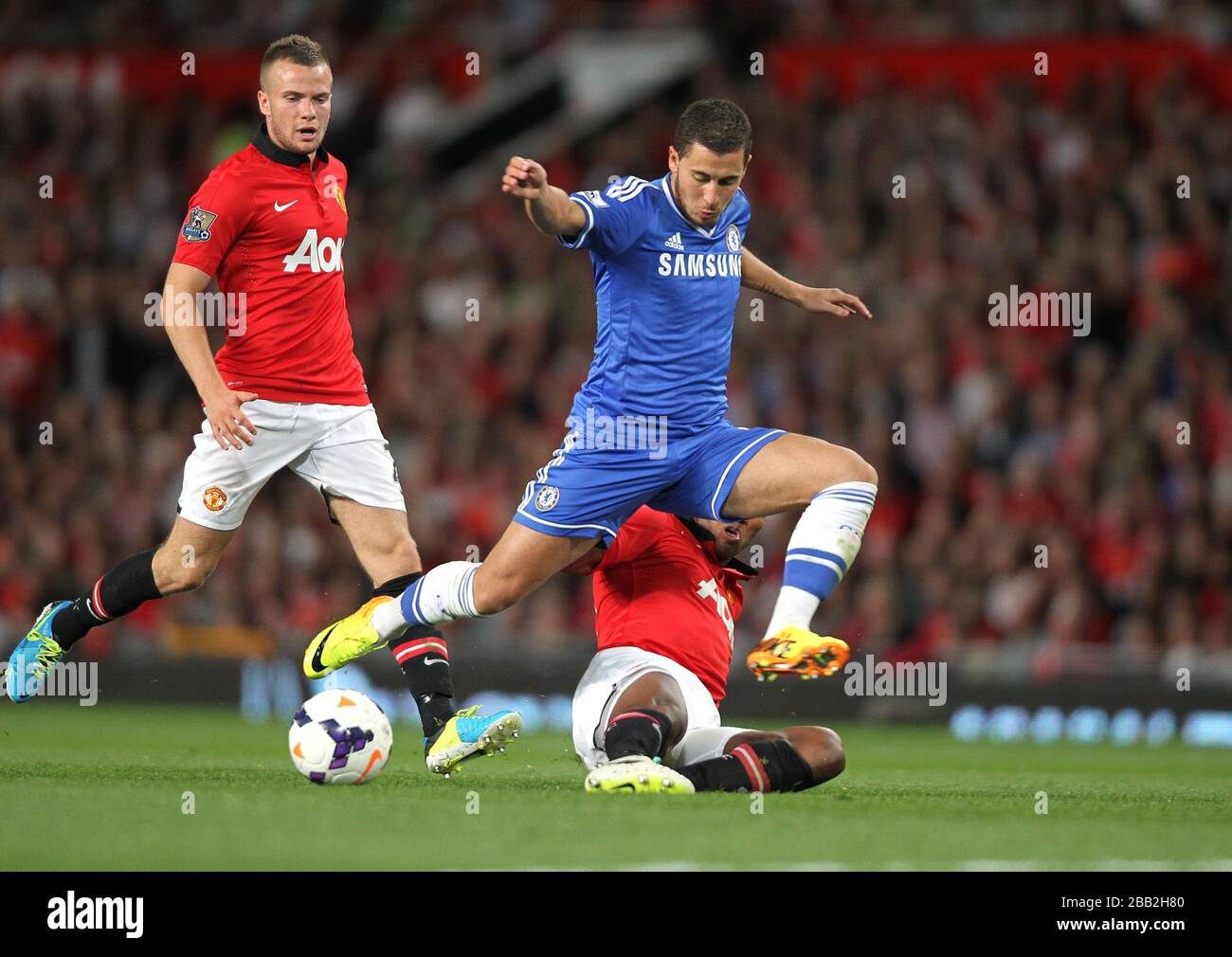 Manchester United's Antonio Valencia slides in on Chelsea's Eden Hazard Stock Photo